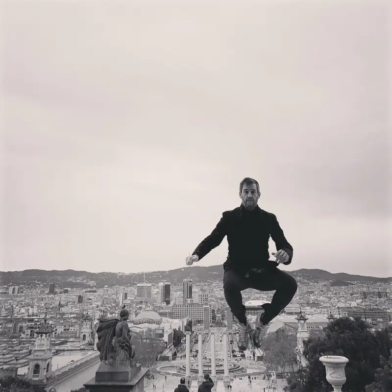 Charly Vaquero saltando en el aire frente al skyline de Barcelona, fotografía en blanco y negro